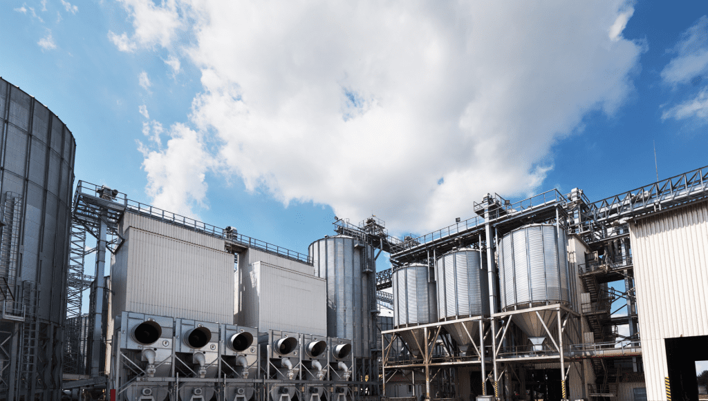 A wide view of Sevington Energy's industrial complex with large metal storage tanks and pipelines under a bright blue sky, showcasing the company's extensive facilities.