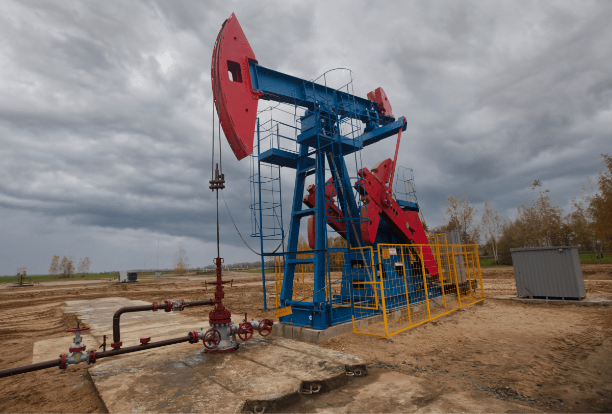 An oil pump jack in operation under a cloudy sky, symbolizing Sevington Energy's involvement in traditional oil extraction methods.